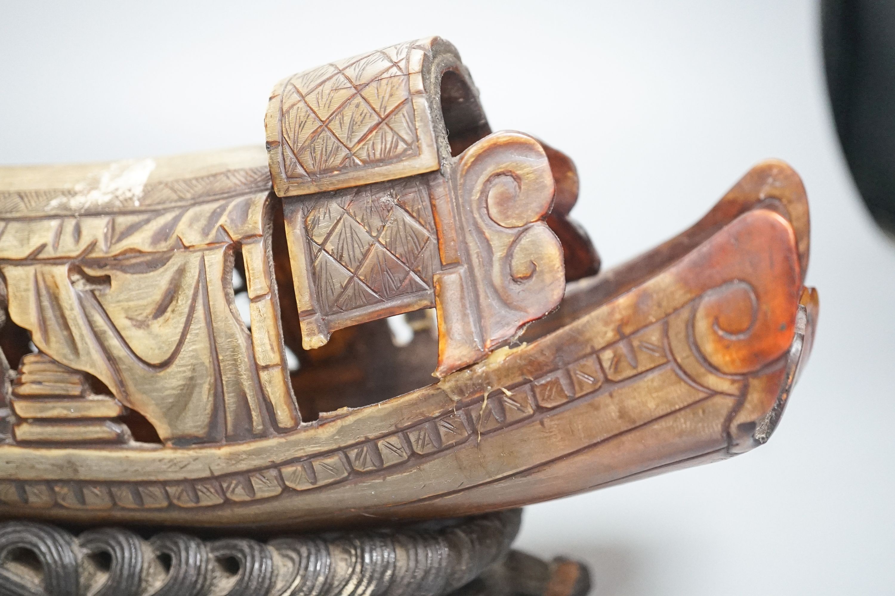 A Chinese horn carving of a junk boat, wood stand, 34cm